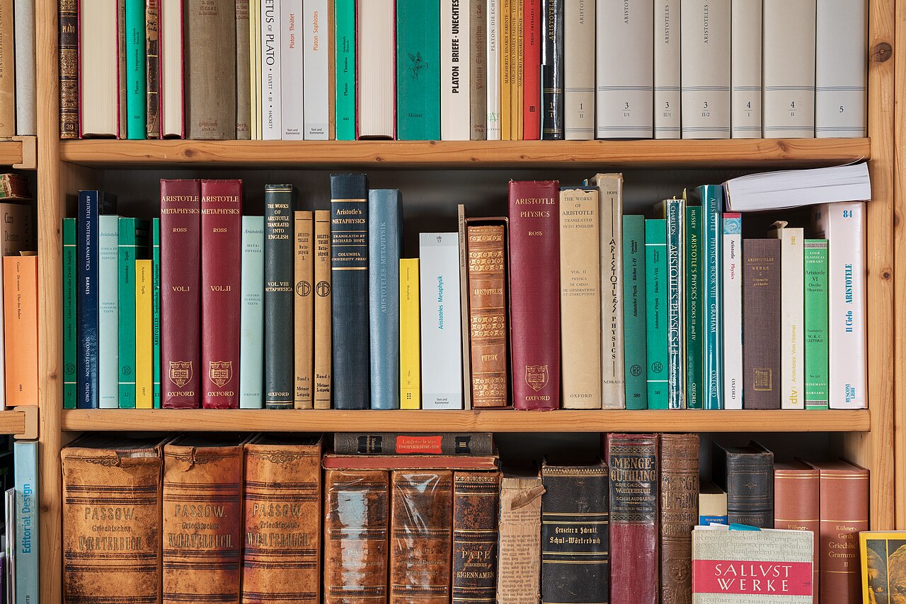 A wooden bookshelf filled with classic volumes