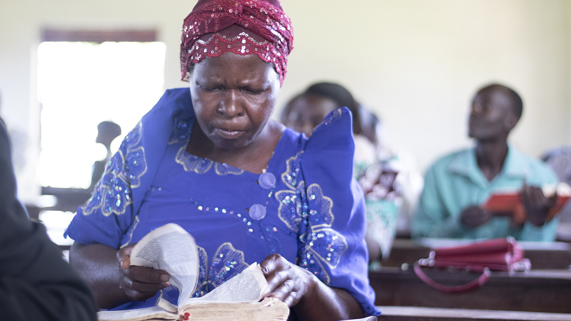 A woman reading an open Bible in a church sanctuary