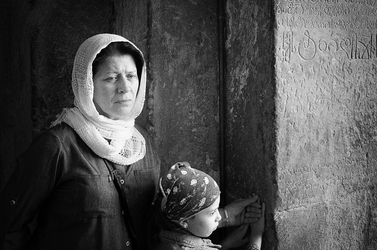 A Georgian family praying in a church, inviting reflection on depending on God in prayer before conversations about the gospel.