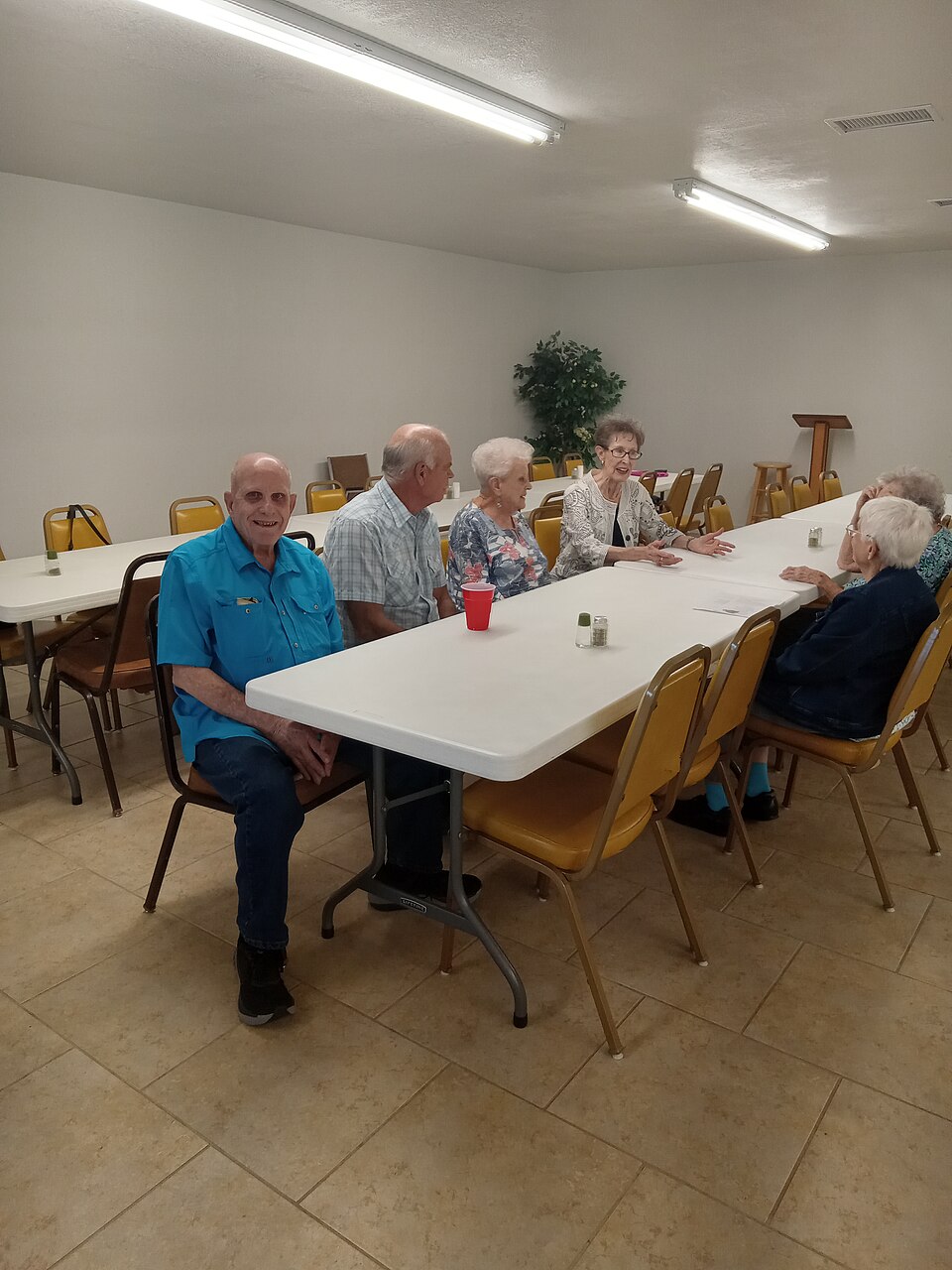 People talking around a long table in a church fellowship room