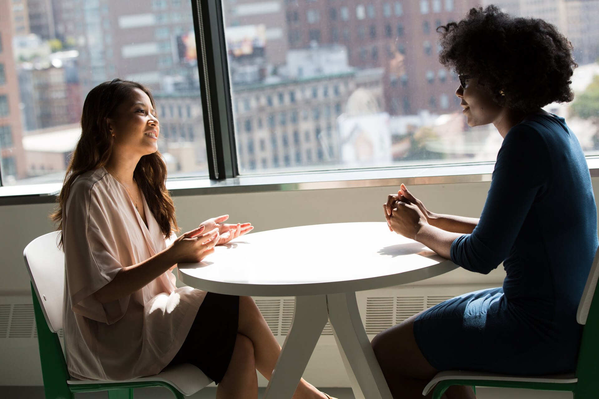 Two women in conversation across a table.