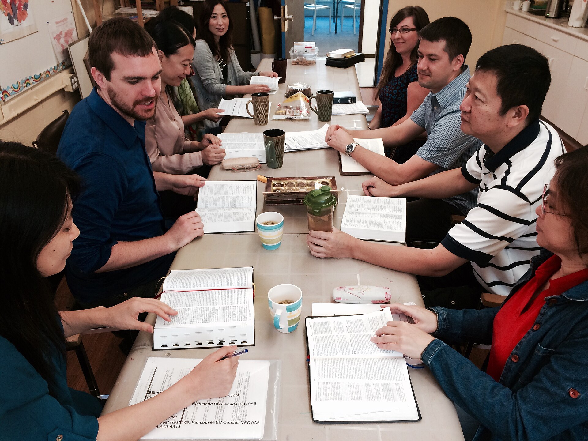 A small group reads Bibles together around a table.