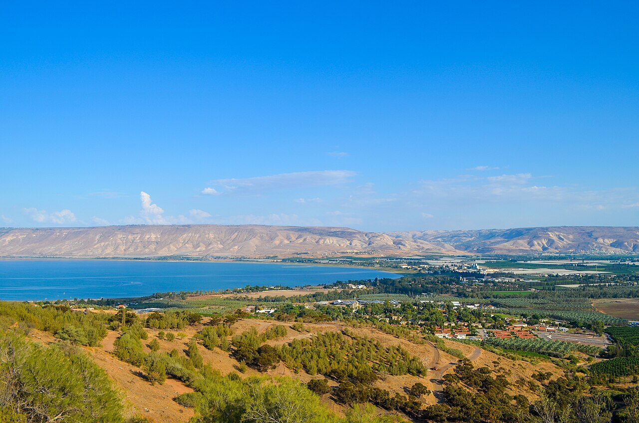 A modern view of the blue Sea of Galilee and surrounding hills